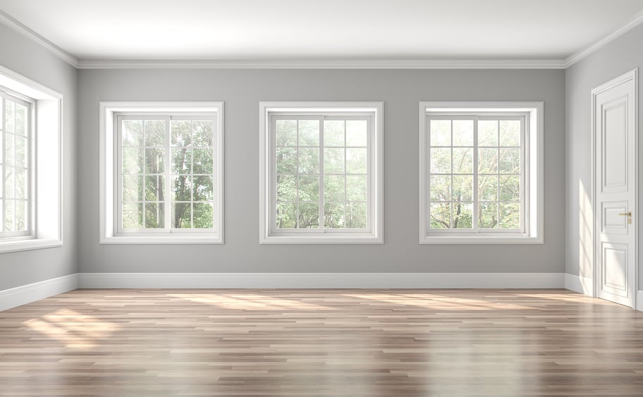 Interior of a room with four large slider windows with white grids