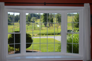 Interior view of a bay window looking over grassy fields