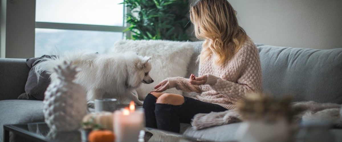Woman sitting with her dog on a living room couch